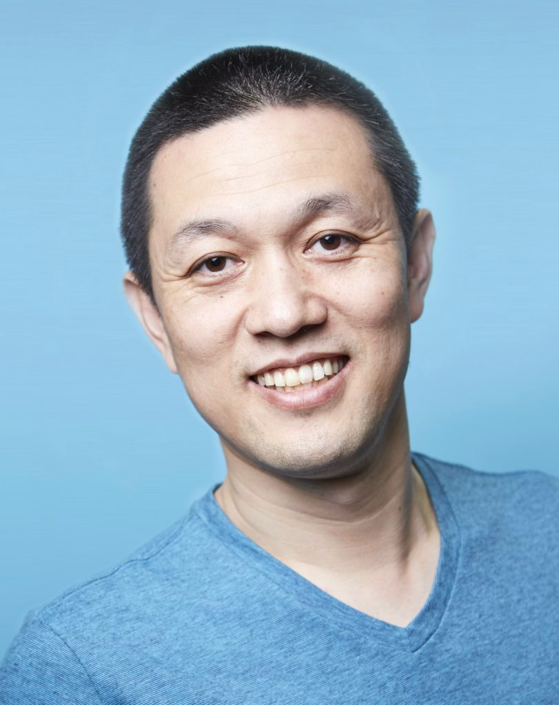 A portrait of NIO founder William Li against a blue background.